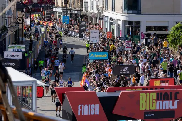 A group of runners heading towards the finish line at The Big Half, a large crowd of spectators gathered on the right hand side behind barriers