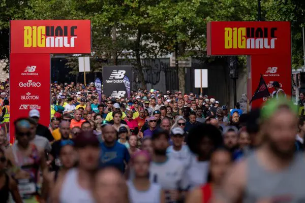 A group of runners all bunched together going over the start line at The Big Half